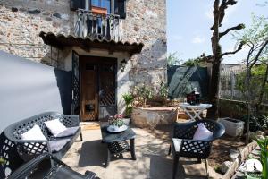 un patio con sillas y una mesa frente a un edificio en Camere Belgioioso, en bedizzol