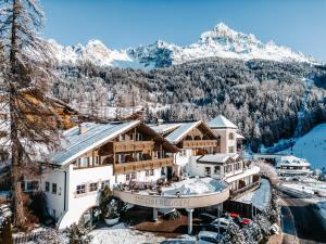 a hotel with snow covered mountains in the background at Hotel Obereggen in Obereggen