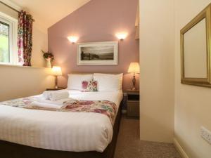 a small room with a bed with two lamps at Chalet Log Cabin L15 in Ilfracombe