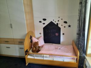 Vögelhof في Doren: غرفة نوم للأطفال مع سرير أطفال مع دمية دب