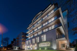 un grand bâtiment avec un panneau la nuit dans l'établissement Aurum Aparthotel - Nowe Apartamenty blisko Plaży - Neue Appartements in Strandnähe, à Świnoujście