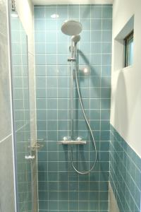 Łazienka wyposażona jest w niebieski prysznic z głowicą prysznicową. w obiekcie YAMO-Izukogen w mieście Yawatano