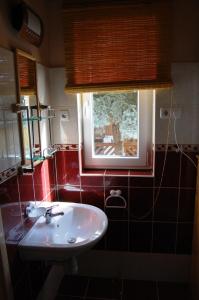 a bathroom with a sink and a window at Maya Guesthouse in Eger