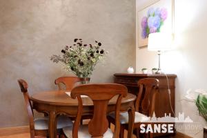 una mesa de comedor con sillas y un jarrón de flores en Apartamento Usan, en San Sebastián