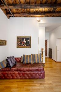 a red couch in a living room with a wooden floor at Pantheon Caravaggio's House in Rome