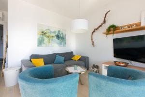 salon z niebieskimi krzesłami i kanapą w obiekcie Apartment Libelle 5 star apartment in Krk! w Krku