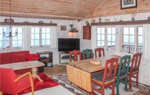 een woonkamer met een tafel en stoelen en een televisie bij Cozy Home In Tuddal With Kitchen in Tuddal
