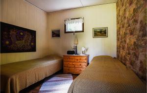 a bedroom with two beds and a dresser and a window at 2 Bedroom Lovely Home In Slite in Slite