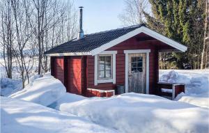 a small red cabin with snow around it at Awesome Home In Lima With Sauna And 2 Bedrooms in Lima