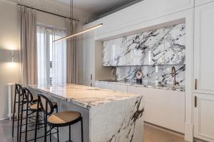 uma cozinha com um balcão de mármore e bancos em BNBHolder Luxe GRAN VIA em Madri