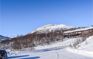 a snow covered mountain in front of a building at Hovden Alpin Apartments in Hovden