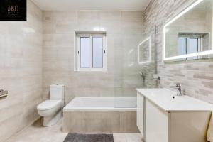 uma casa de banho com uma banheira, um WC e um lavatório. em Stunning 3BR w/Country View Apartment in M'Scalak by 360 Estates em Marsaskala