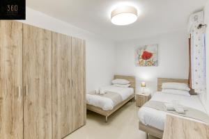 Duas camas num quarto com armários de madeira em Stunning 3BR w/Country View Apartment in M'Scalak by 360 Estates em Marsaskala