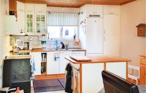 cocina con armarios blancos y mesa de madera en Lovely Home In Erikslund With Kitchen en Erikslund