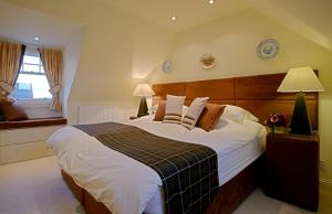 Un dormitorio con una cama grande y una ventana en Loaninghead Holidays, en Drymen