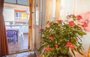 d'un balcon avec une table et une plante ornée de fleurs roses. dans l'établissement Stunning Apartment In Srima With Wifi, à Srima