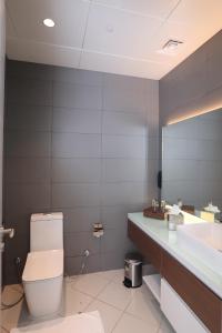 a bathroom with a toilet and a sink and a mirror at eStay Hotel in Dubai