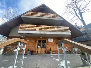 ein großes Holzgebäude mit einem großen Dach in der Unterkunft Willa Sienkiewiczówka in Zakopane