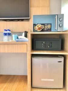 a kitchen with a microwave and a dishwasher at Double Happiness Hotel in Seri Manjung