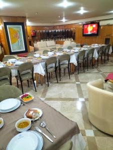 a dining room with tables and chairs and a television at SPOR HOTEL in Ankara