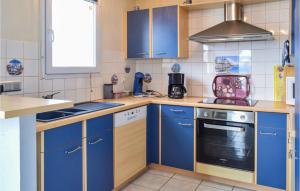 eine Küche mit blauen Schränken und einem Herd in der Unterkunft Nice Home Saint Germain in Saint-Germain-sur-Ay