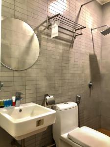 a bathroom with a sink and a toilet and a mirror at Double Happiness Hotel in Seri Manjung