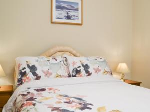 ポーティンズケールにある1 Harney Peakのベッドルーム1室(花柄の枕付きのベッド1台付)