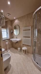 ein Bad mit einem Waschbecken, einem WC und einer Dusche in der Unterkunft Albergo Trieste in Boves
