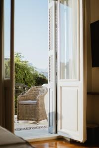 an open door to a patio with a wicker chair at The Bold Type Hotel, a Member of Design Hotels in Patra