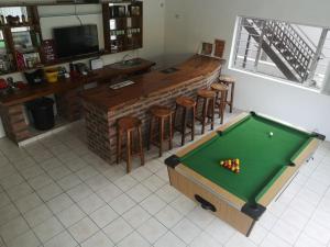 a pool table in front of a bar with stools at Villa Incognito in Clansthal