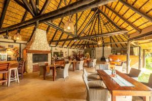 comedor grande con mesas y sillas de madera en Gecko Ridge, en Swakopmund