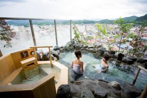 two children playing in a jacuzzi in a spa at Takayama Ouan in Takayama