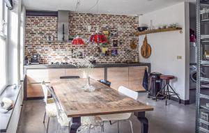 cocina con mesa de madera y pared de ladrillo en Kapeltuin en Hoorn