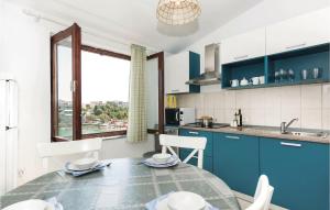 a kitchen with blue cabinets and a table with chairs at Cozy Apartment In Kanica With Wifi in Zaglavice