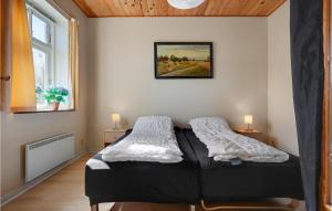 een slaapkamer met een bed en een schilderij aan de muur bij Stunning Apartment In Allingbro With Wifi in Allingåbro