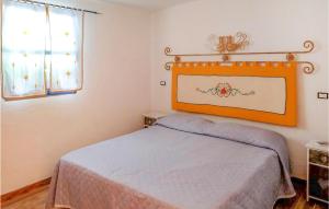 um quarto com uma cama com uma cabeceira laranja e uma janela em 2 Bedroom Stunning Home In Oliena em Oliena