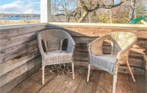 two wicker chairs sitting on the porch of a house at Stunning Home In Botolfsbo With Lake View 
