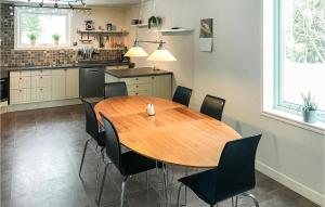 a kitchen with a wooden table and black chairs at Beautiful Home In Torpshammar With 2 Bedrooms in Torpshammar