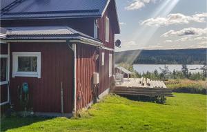 ein rotes Gebäude mit einem Dock neben einem Wasserkörper in der Unterkunft Stunning Home In Torpshammar With Kitchen in Torpshammar