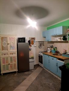 uma cozinha com armários azuis e um frigorífico em KUĆA ZA ODMOR JURINO GNIJEZDO em Jarki Horvatićevi