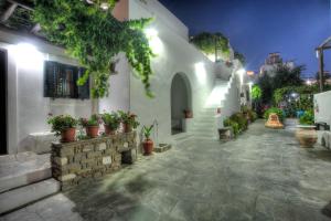 a courtyard of a white building with potted plants at Eleni Dream Village in Parikia