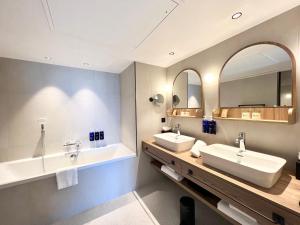 ein Badezimmer mit zwei Waschbecken und zwei Spiegeln in der Unterkunft Emeria Dinard Thalasso Spa in Dinard