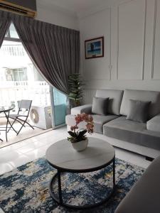 een woonkamer met een bank en een tafel bij Hanizz Vacation Home in Kampong Bukit Darat