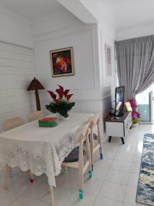 Kampong Bukit Darat的住宿－Hanizz Vacation Home，一间配备有白色桌椅的用餐室
