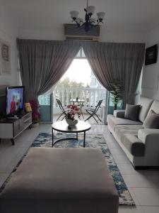 a living room with a couch and a table at Hanizz Vacation Home in Kampong Bukit Darat
