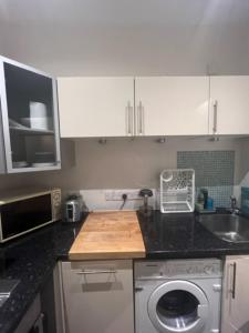 a kitchen with a sink and a washing machine at Peaceful 1 Bedroom Flat near Highbury and Islington in London