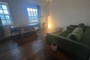 a living room with a green couch and a table at Peaceful 1 Bedroom Flat near Highbury and Islington in London