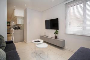 a living room with a couch and a tv on a wall at Magnificent apartment 506 The Granger in Cape Town