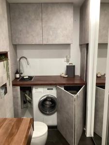 uma casa de banho com uma máquina de lavar roupa e um WC em In the Heart of Port Melbourne em Melbourne