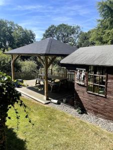 a gazebo with a picnic table in a yard at Open plan area sleeping up to 2 adults & 2 children in Bideford